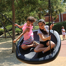 Children swinging on a group swing seat